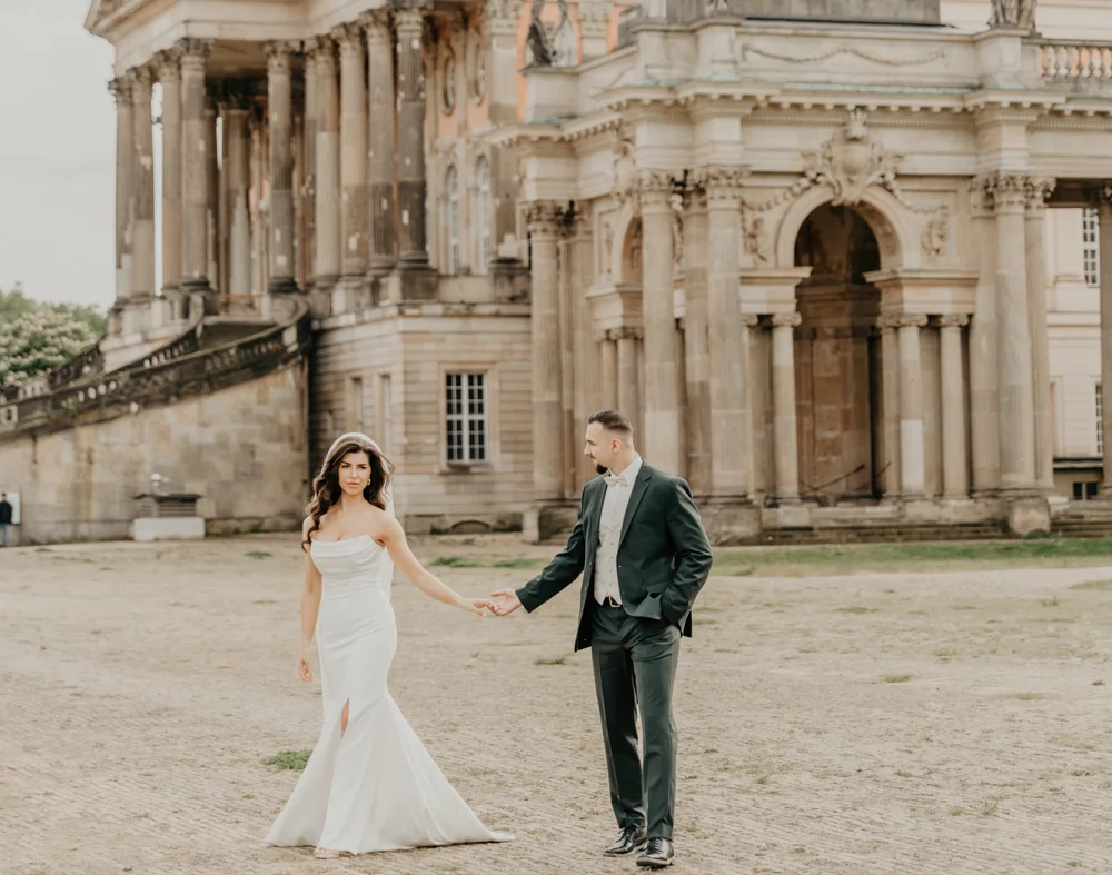 Brautpaar beim Spaziergang vor dem Schloss